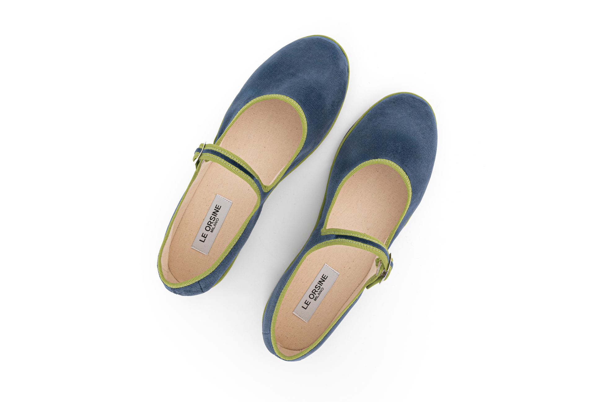 A navy velvet slipper with a Maryjane style closure and a flat sole.