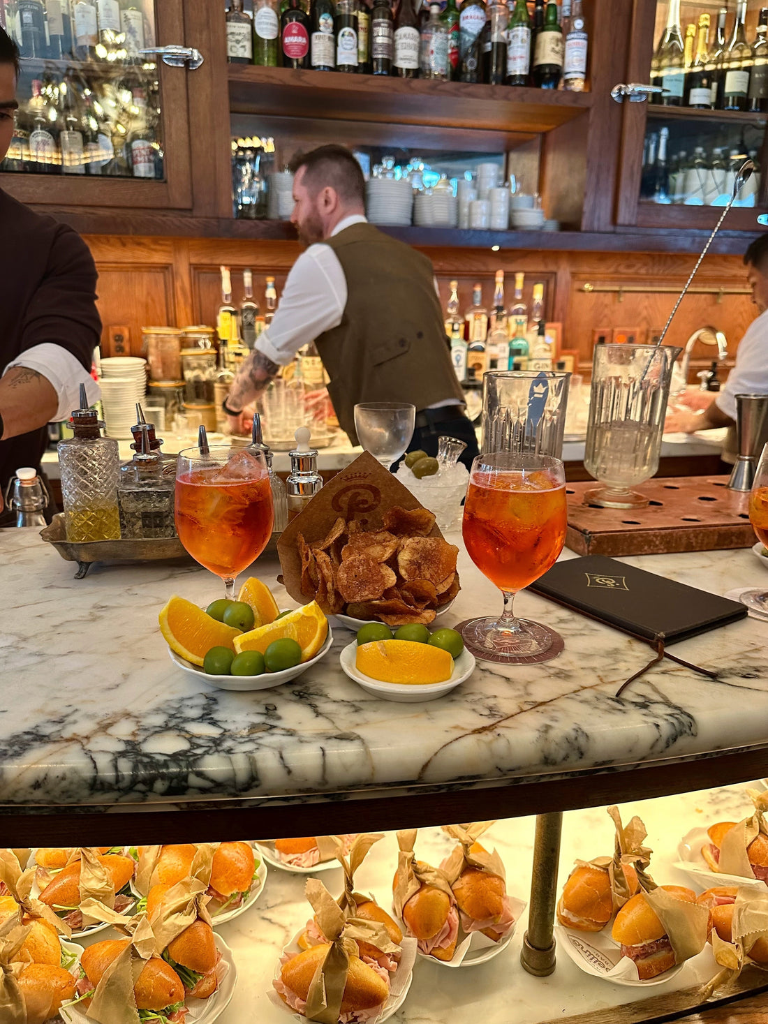 Le Orsine favorite spots NYC featuring cocktails, bar setting, and gourmet snacks.