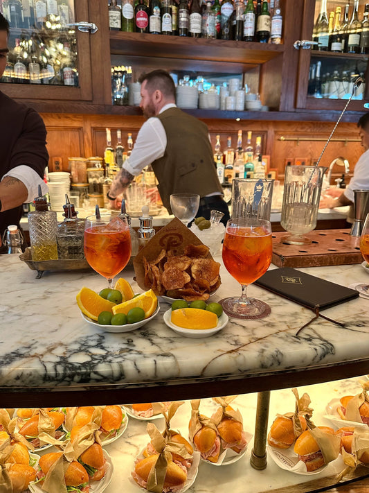 Le Orsine favorite spots NYC featuring cocktails, bar setting, and gourmet snacks.