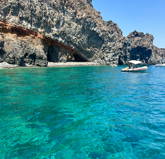 A serene view of the turquoise waters and rocky coastline featured in a travel guide to Pantelleria.