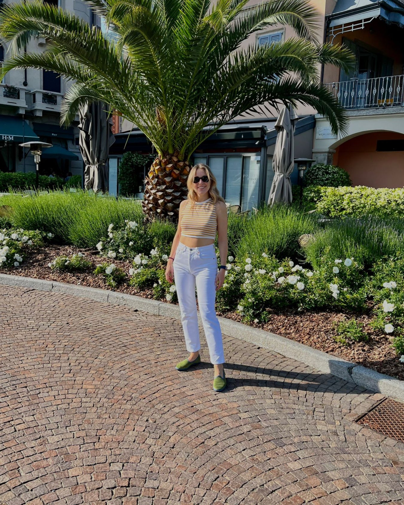 Woman standing on a cobblestone path with wearing Le Orsine Velvet Slippers